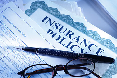 a close up of a glasses and insurance forms